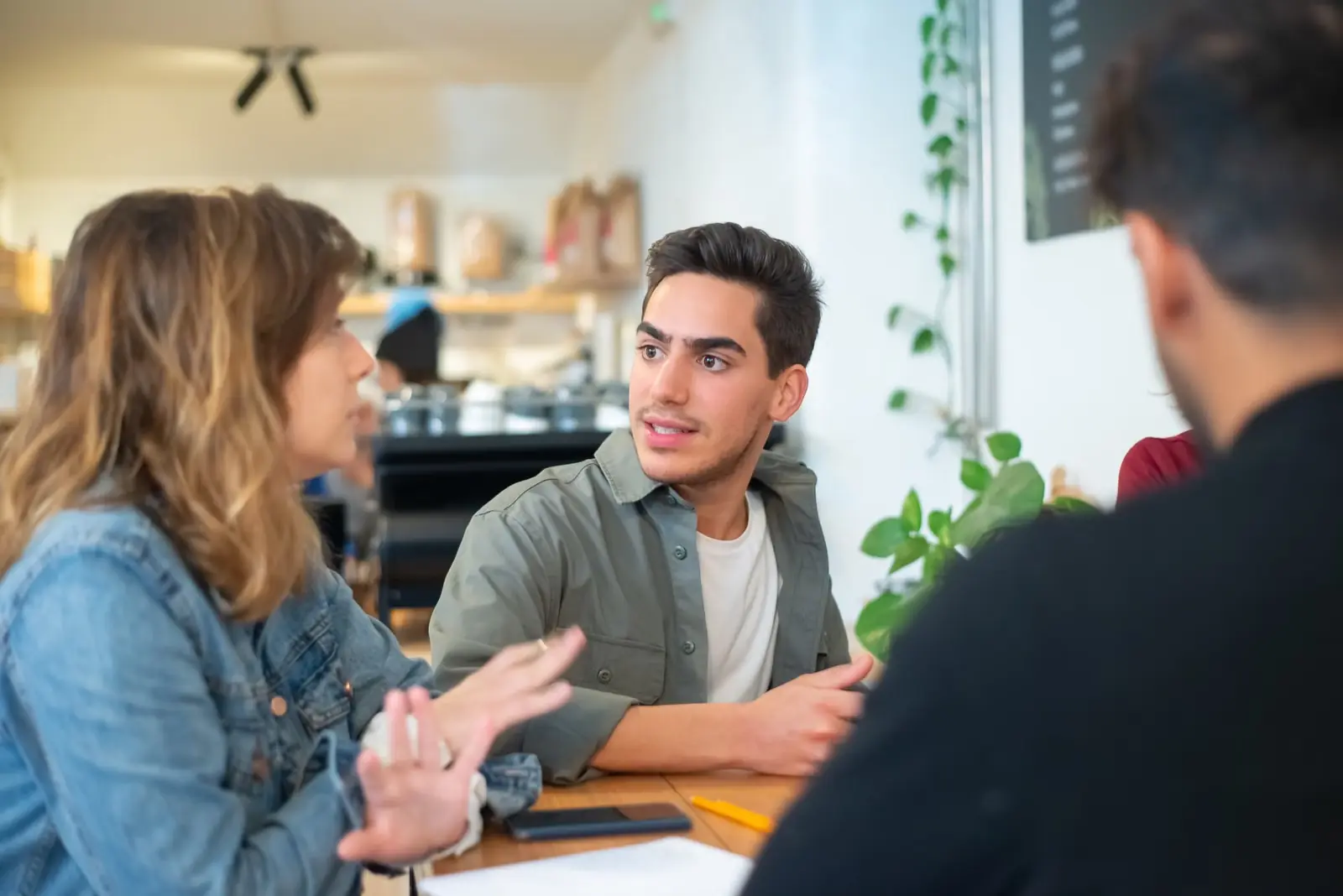 People sitting at a wooden table in everyday conversation.